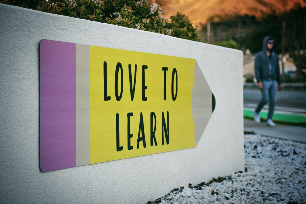 A wall with a pencil painted on it. The pencil says, "Love to learn."